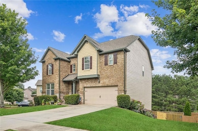 View of front of property featuring driveway, a garage, brick siding, and roof with shingles