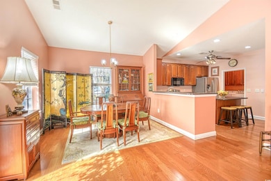 Dining room with lofted ceiling, light hardwood / 