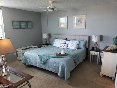 Carpeted bedroom featuring a textured ceiling and ceiling fan