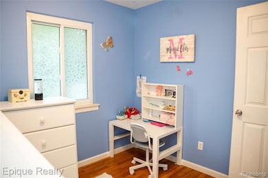 Bedroom with wood finished floors and baseboards