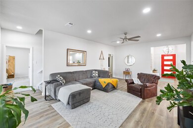 Living room with ceiling fan and light hardwood / 