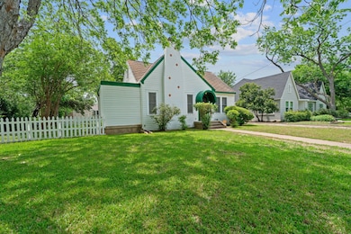 View of front facade featuring fence, roof with s