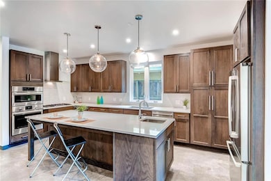 Kitchen featuring an island with sink, stainless 