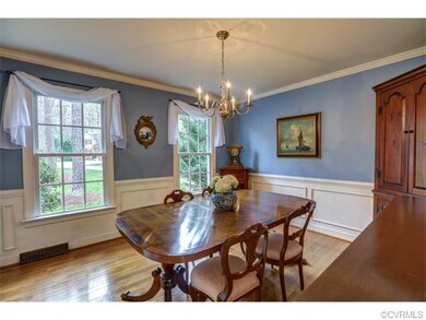 An elegant, spacious formal dining room with pictu
