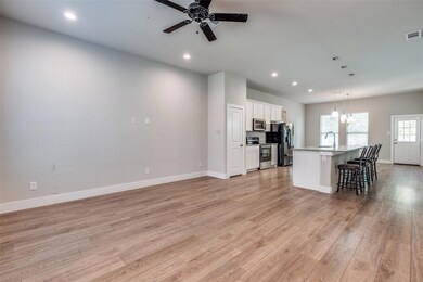 Kitchen featuring a center island with sink, white
