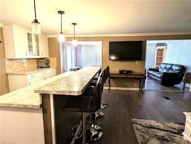 Kitchen featuring white cabinets, glass insert cab