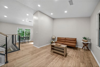 Living area with hardwood / wood-style floors, baseboards, and recessed lighting