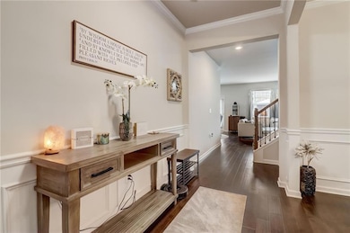 Hallway with ornamental molding and dark hardwood / wood-style floors