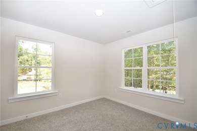 Empty room featuring carpet and attic access