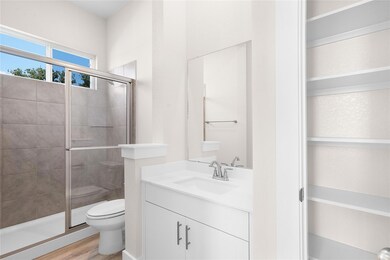 Bathroom featuring toilet, vanity, a stall shower