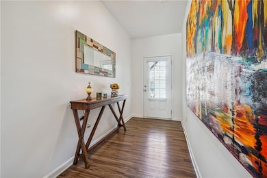 Doorway to outside featuring baseboards and wood f