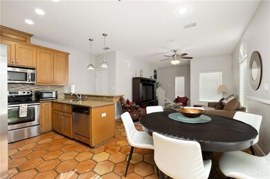 Kitchen featuring pendant lighting, sink, ceiling fan, kitchen peninsula, and stainless steel appliances