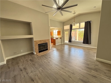 Unfurnished living room with a ceiling fan, vaulte
