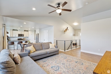 Living room featuring recessed lighting, vaulted ceiling, light wood-type flooring, and a ceiling fan