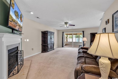 Living room featuring a ceiling fan, light colored