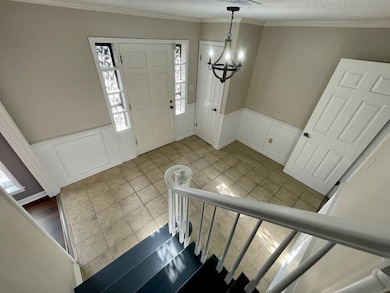 Foyer with a wainscoted wall, ornamental molding, 