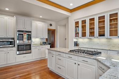 Glass-front cabinetry adds character and display space, while under-cabinet lighting brings warmth and function.