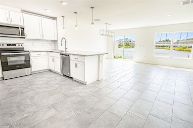 Kitchen featuring open floor plan, a peninsula, ba