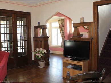 A view of the lovely front entryway woodwork and refinished hardwood floors in the living room leading into the sunroom.