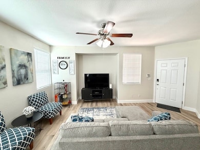 Living room featuring ceiling fan, wood finished f