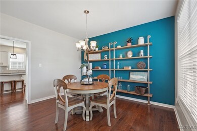 Dining room with a chandelier and dark hardwood /