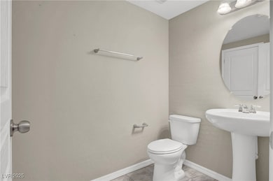 Bathroom with toilet, baseboards, tile patterned f