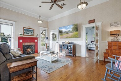 Living area featuring ceiling fan, a warm lit fir