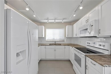Kitchen featuring white appliances, granite counte