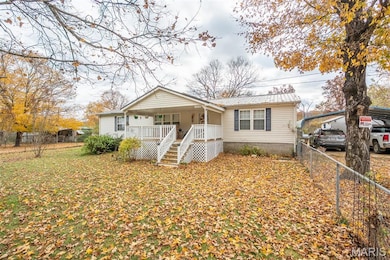 View of front of home featuring a metal roof, a porch, and a carport