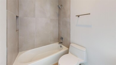 Bathroom featuring toilet and tiled shower / bath 