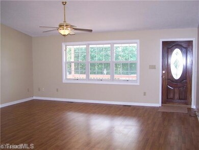Living Room. Large Great Room! This room offers vaulted ceilings, nice natural light, ceiling fan, gas logs, laminate wood floors, a gorgeous leaded glass front door, and fresh paint!