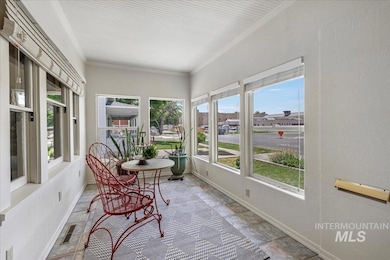 Sunroom featuring crown molding and stone finish floors