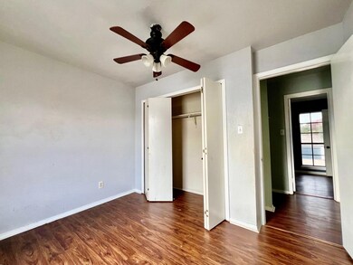 Unfurnished bedroom featuring ceiling fan, dark ha