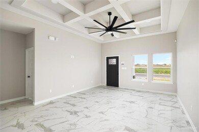 Tiled empty room with coffered ceiling, beamed ceiling, and ceiling fan