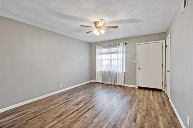 Empty room featuring ceiling fan, dark wood finish