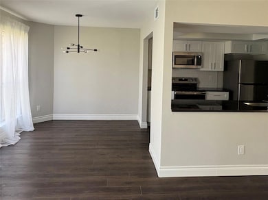 Kitchen with a notable chandelier, dark counterto