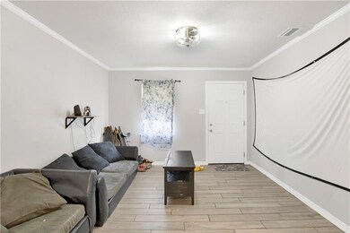 Living area with ornamental molding and light wood-type flooring