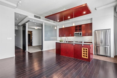 Kitchen featuring stainless steel appliances, open shelves, wood finished floors, reddish brown cabinets, and tasteful backsplash