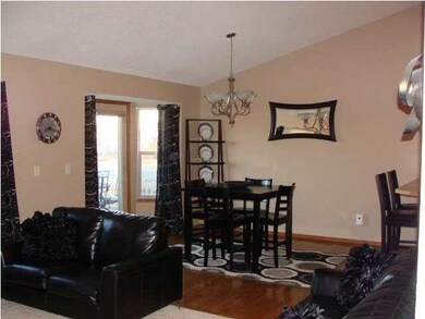 Eating area has hardwood floors with the door goin