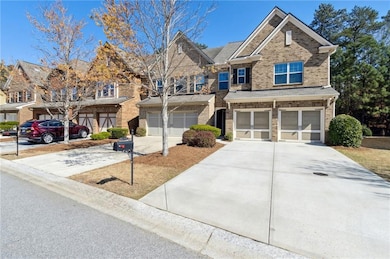 View of front of property featuring an attached garage, concrete driveway, and brick siding