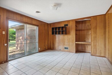 Tiled spare room with wooden walls and a textured 