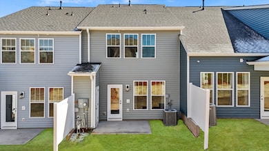 Townhome exterior with craftsman design, large windows, garage, two car parking pad, and blue siding at Aspen Ridge in Lyman