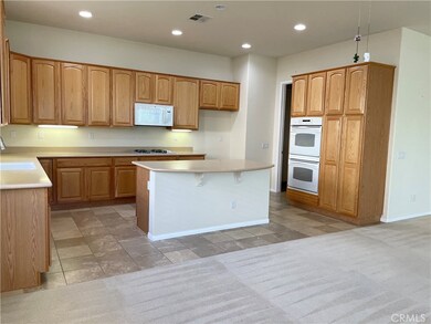 Large, open kitchen with solid surface countertops, great for entertaining.