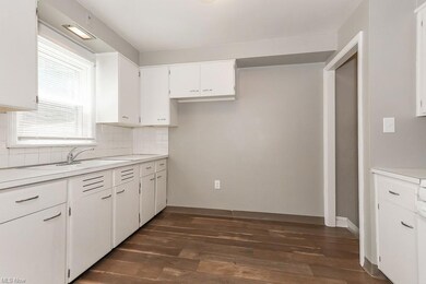 Kitchen with light countertops, white cabinetry, b