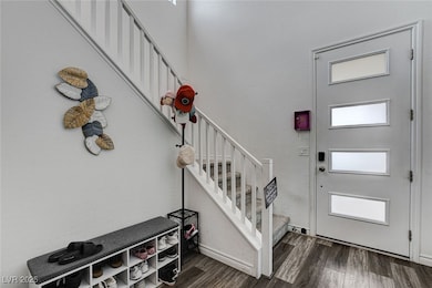 Foyer entrance with stairway and wood finished flo