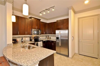 Kitchen featuring backsplash, light stone counters, appliances with stainless steel finishes, sink, and ornamental molding
