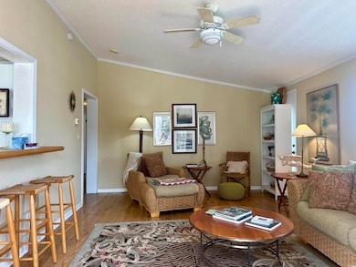 Living room with ceiling fan, a textured ceiling, 