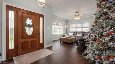 Entrance foyer with dark hardwood / wood-style floors, ceiling fan, and ornamental molding