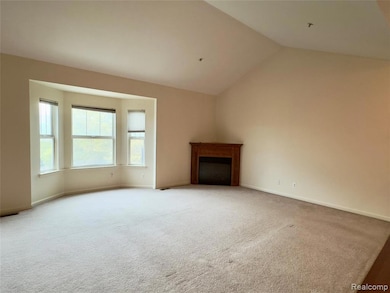 Unfurnished living room with carpet, a fireplace, and lofted ceiling