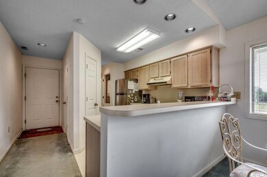 Kitchen featuring light carpet, a textured ceiling